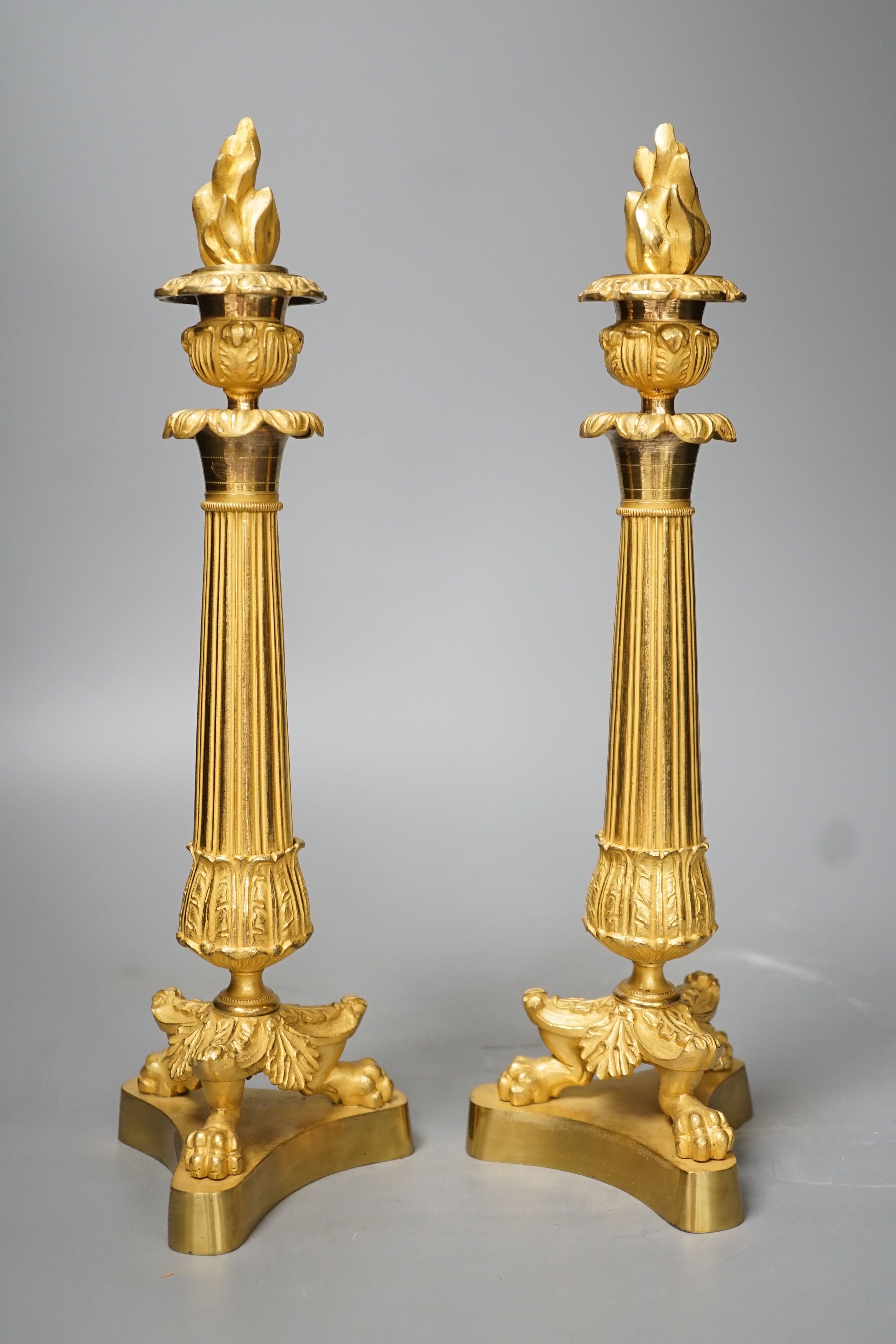 A pair of Louis XVI style ormolu candlesticks with torched stoppers - 32cm high